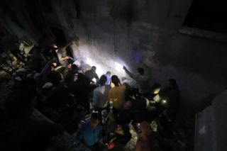 |Palestinians search among the rubble on the martyrs and the injured after the treachery planes targeting the security personnel in their house.

فلسطينيون يقومون بالبحث بين...
