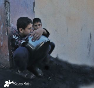 |This child is waiting for the end of the food to take his share and go home to eat it with his family.

هذه الطفل ينتظر انتهاء الاكل لياخذ نصيبه ويذهب الي...