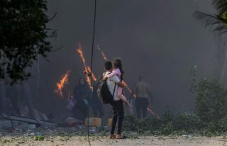 A man holding a child on his arms trying to flee from the bombardment in Gaza #gaza #epaimages #palestine #gazaunderattack