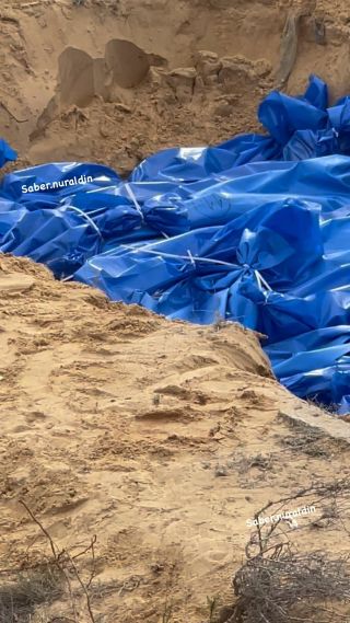The bodies of 111 Palestinians killed in Israeli strikes on Gaza are placed in a mass grave during their burial at the Khan Younis cemetery in the southern Gaza Strip, 22 November 2023. More than...