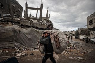 Residents leave their homes with their belongings after the Israeli army attacked the eastern part of the Nuseirat refugee camp and sent a notice asking the people to leave the area in Deir al Balah,...