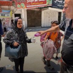 مواطنون يوزعون الماء على النازحين من منطقة الشجاعية لتخفيف عنهم حر الشمس