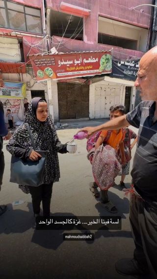 مواطنون يوزعون الماء على النازحين من منطقة الشجاعية لتخفيف عنهم حر الشمس