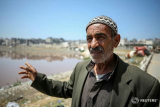 Ali, the grandfather, and Mahmoud, the father of Palestinian boy Zein Oroq, who was wounded after he was hit by aid airdropped on Gaza and later succumbed to his wounds, stand near their house which...