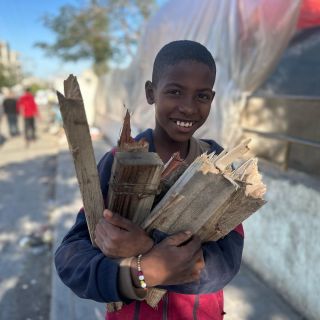 |يا لسعادة هذا الطفل الفلسطيني بحصوله على حزمة من الحطب، إذ يسير مشيًا على الأقدام نحو خيمة نصبتها عائلته عند...