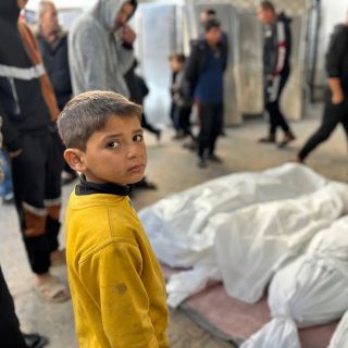 |نظرات بريئة لطفل فلسطيني يقف أمام جثامين فلسطينيين ارتقوا إثر قصف الاحتلال الإسرائيلي منازل المدنيين في...