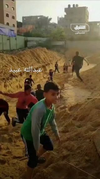 |"بنلعب فيها وبكرة يمكن نندفن فيها" أطفال غزة يلهون بالرمال بعد حفر مقبرة جماعية جديدة بجوار مستشفى...