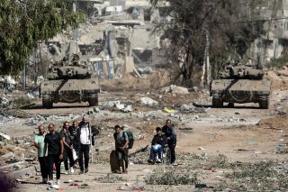 Palestinians flee to northern Gaza as Israeli tanks block the Salah al-Din road in the central Gaza Strip on Friday, Nov. 24, 2023, as the four-day cease-fire in the Israel-Hamas war begins as part...